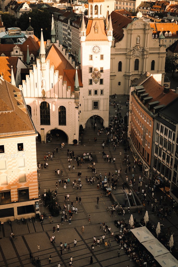 A high angle shot of Munich's Marienplatz showing iconic towers and a bustling square at day.