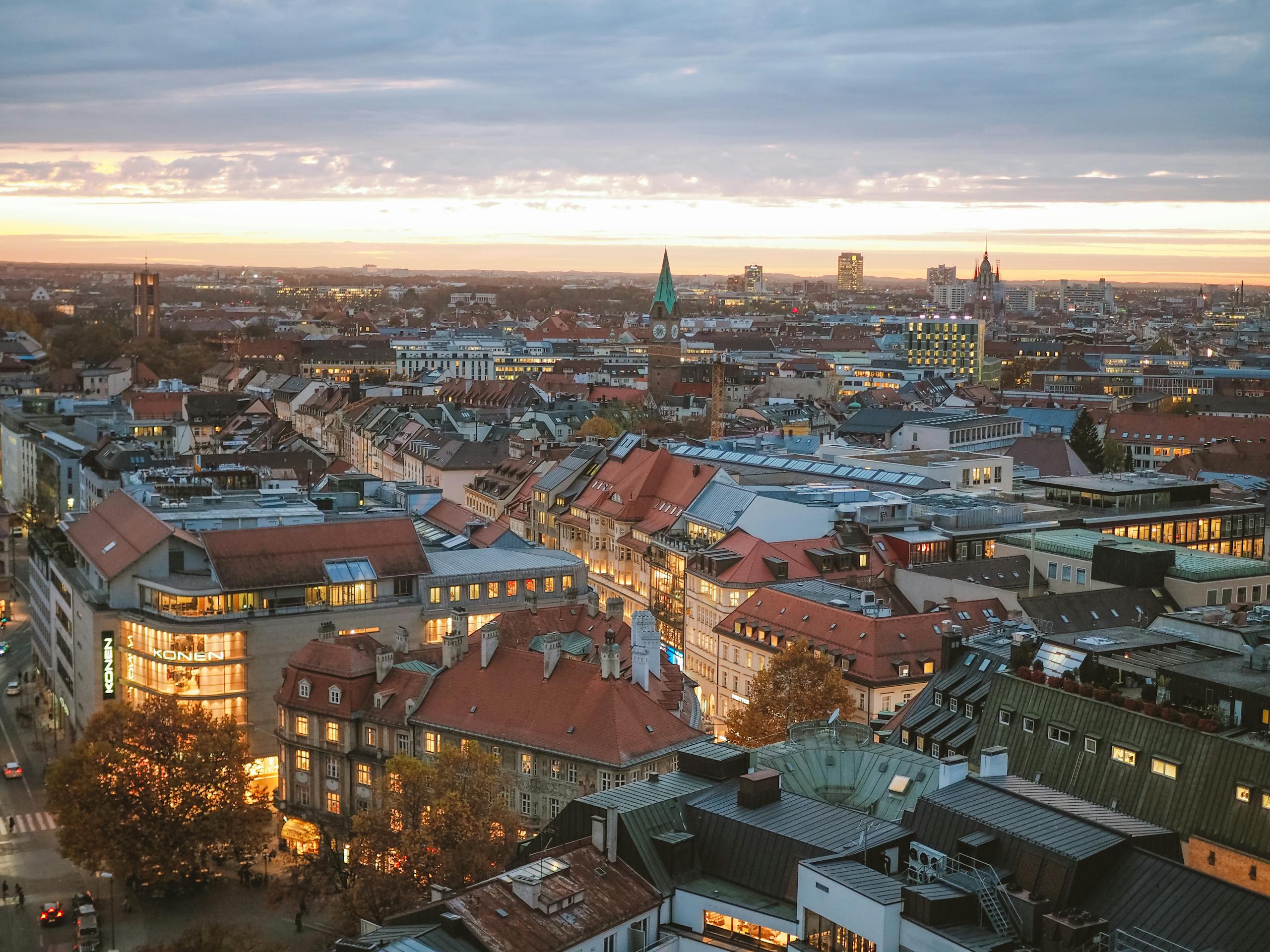 A stunning aerial view of Munich at sunset, showcasing the city's skyline and architecture.