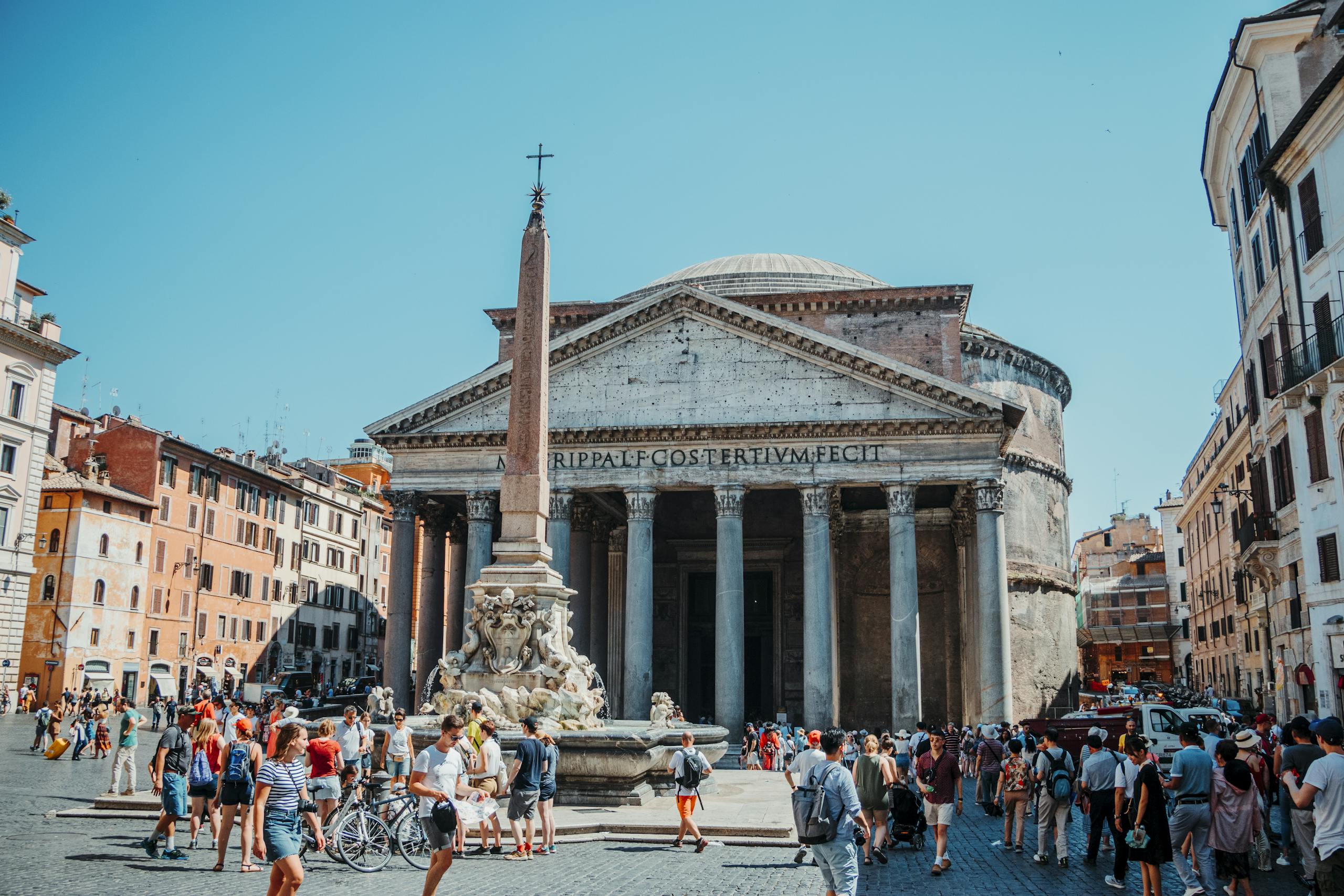 Tourists explore the iconic Pantheon in Rome, Italy on a sunny day.