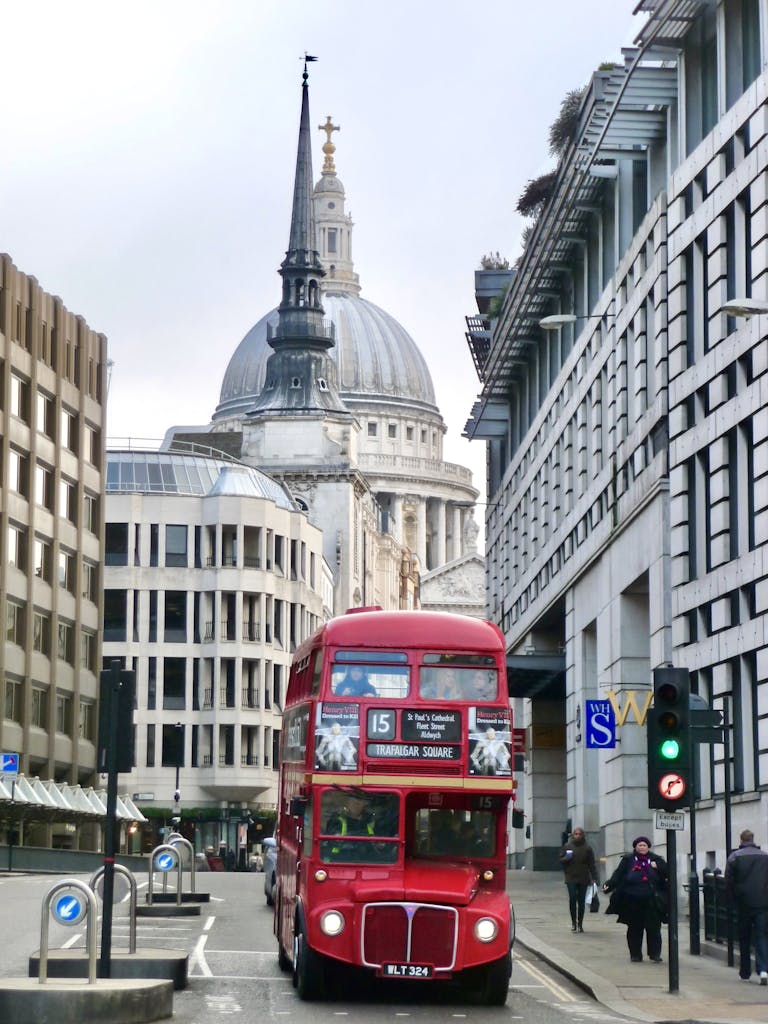 A classic red double-decker bus in front of St Paul's Cathedral, capturing London's charm.