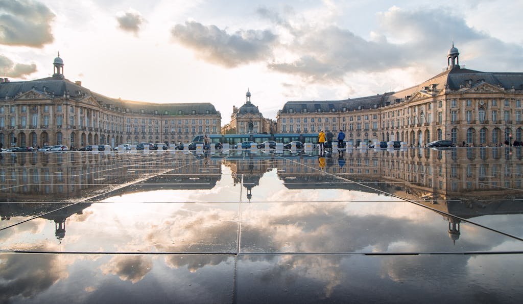 Breathtaking sunset reflection at Place de la Bourse, Bordeaux, France, showcasing historic architecture.