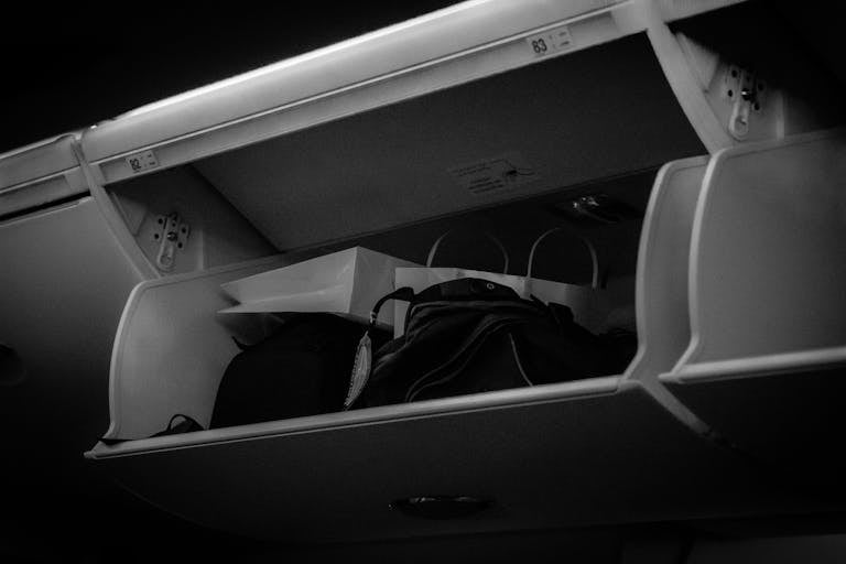 Close-up view of an airplane overhead storage compartment with luggage inside.