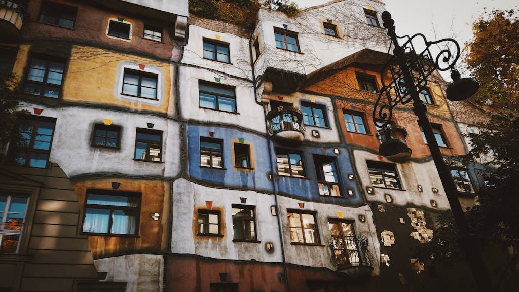 Colorful windows and artistic design on the Hundertwasser House facade in Vienna, Austria.