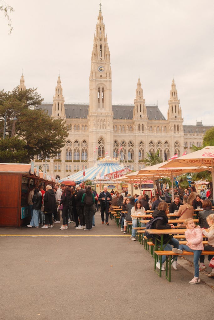 Crowds enjoy an outdoor market at Vienna City Hall, showcasing local culture and architecture.