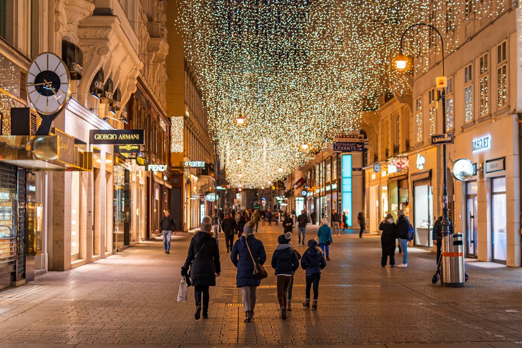 Night view of Vienna's bustling street adorned with holiday lights, capturing the festive vibe.