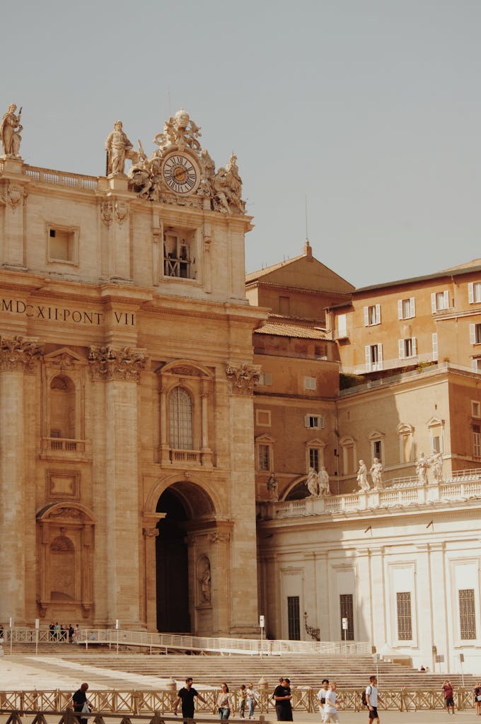 Renaissance architecture of St. Peter's Basilica in Vatican City with tourists in the square.