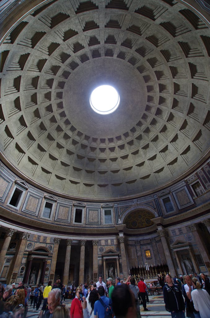 Tourists admire the architectural grandeur inside Rome's historic Pantheon.